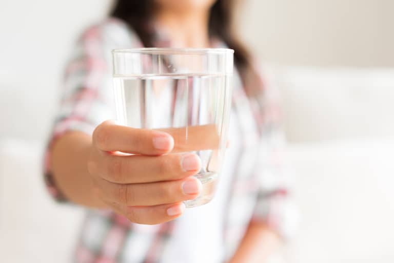 woman holding up glass of water